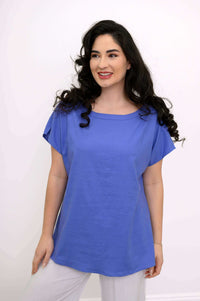 Model smiling and looking sideways in a blue Aria Tee with side slits