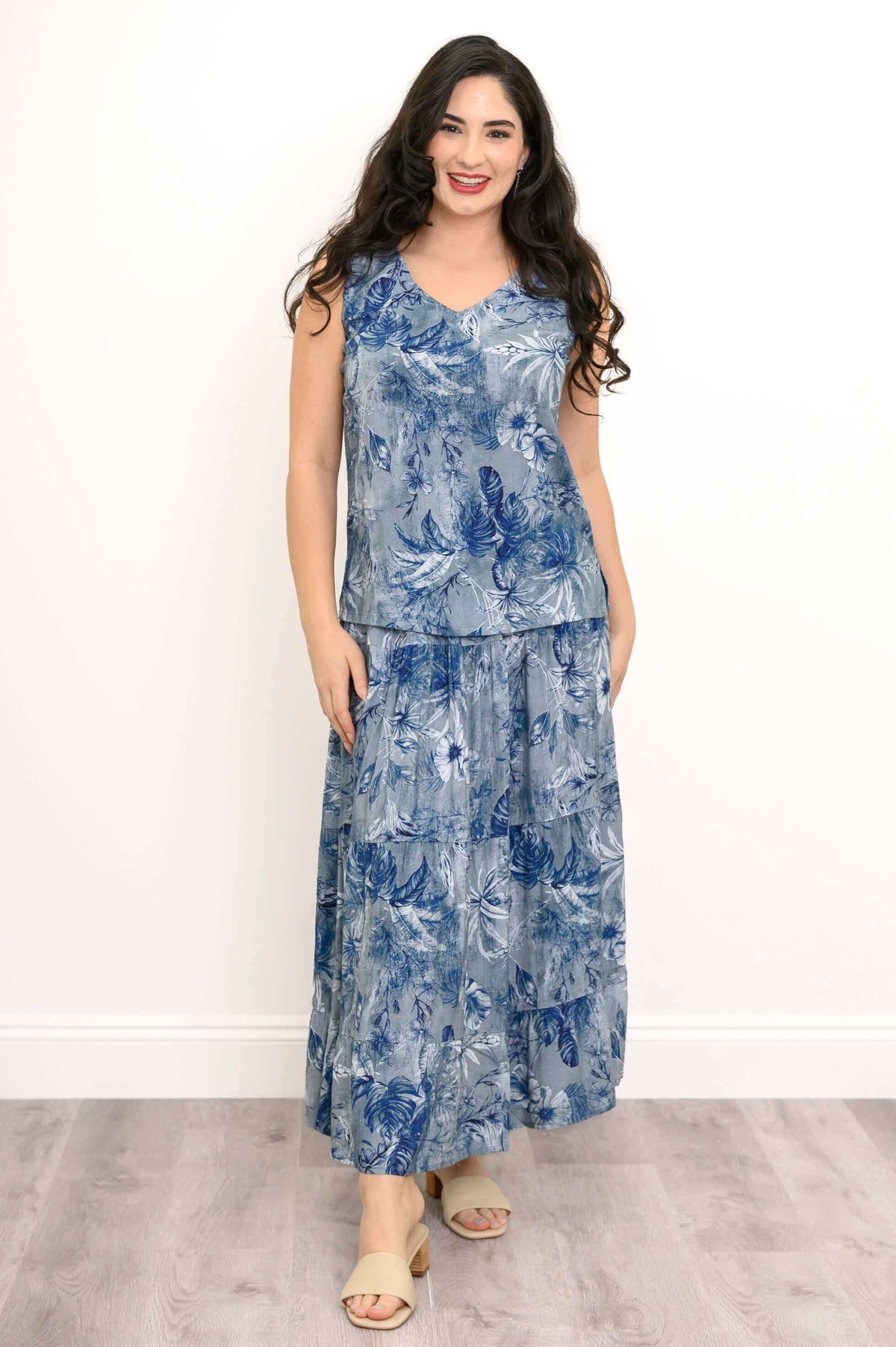 Front view of model in blue botanical tank and skirt, hands by her sides