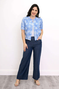 Woman standing in blue floral knit cardigan and navy wide leg pants
