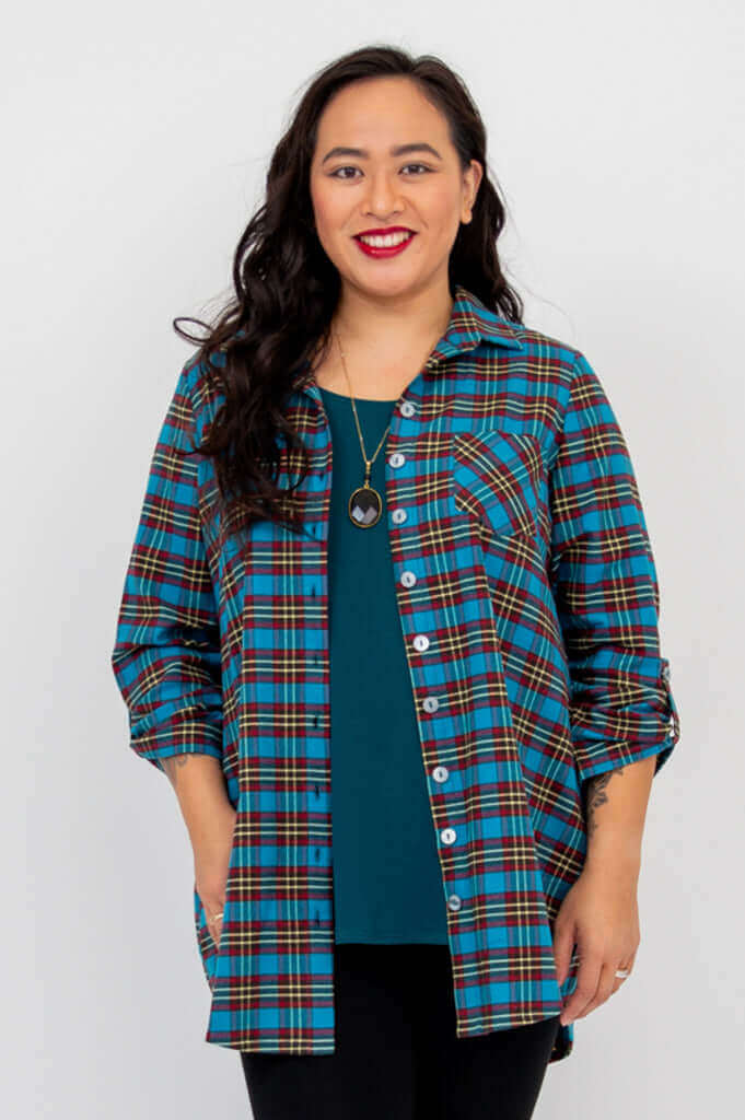 Model in blue plaid oversized flannel tunic with open front and teal top