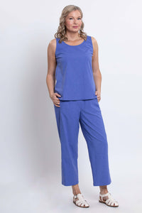Model showing side angle of blue sleeveless top and cropped Boardwalk pants, hands in pockets