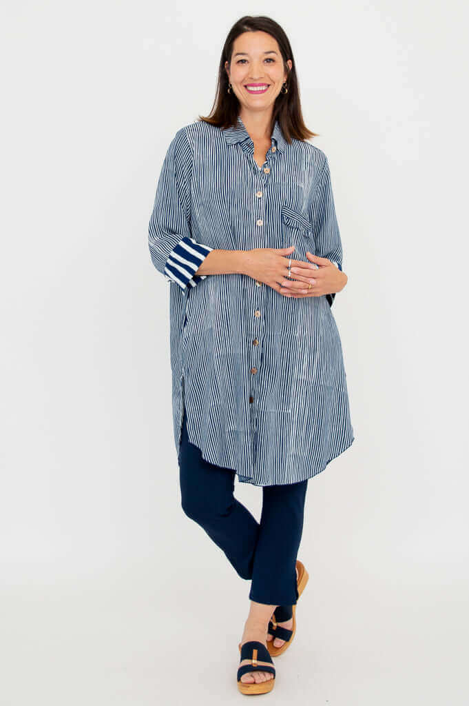 Woman modeling a blue striped oversized shirt with fringe pocket and cuff detail