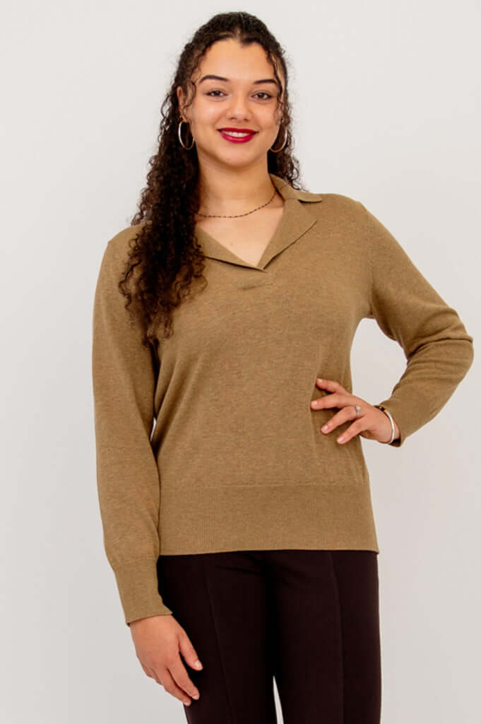 Model wearing brown V-neck cotton sweater with collar, hand on hip