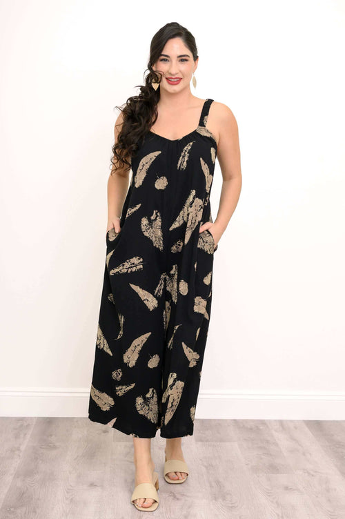 Model wearing a cropped black jumpsuit with tan abstract print and pockets