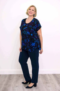 Smiling model wearing midnight blossom curved-hem tunic with pockets and navy pants