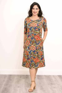 Model in floral bamboo dress with hands in pockets, standing front-facing