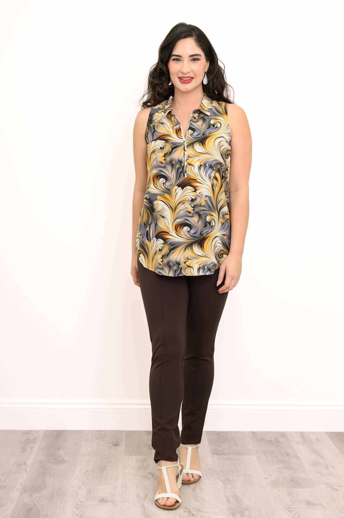 Model standing in golden marble sleeveless top and brown pants, front view