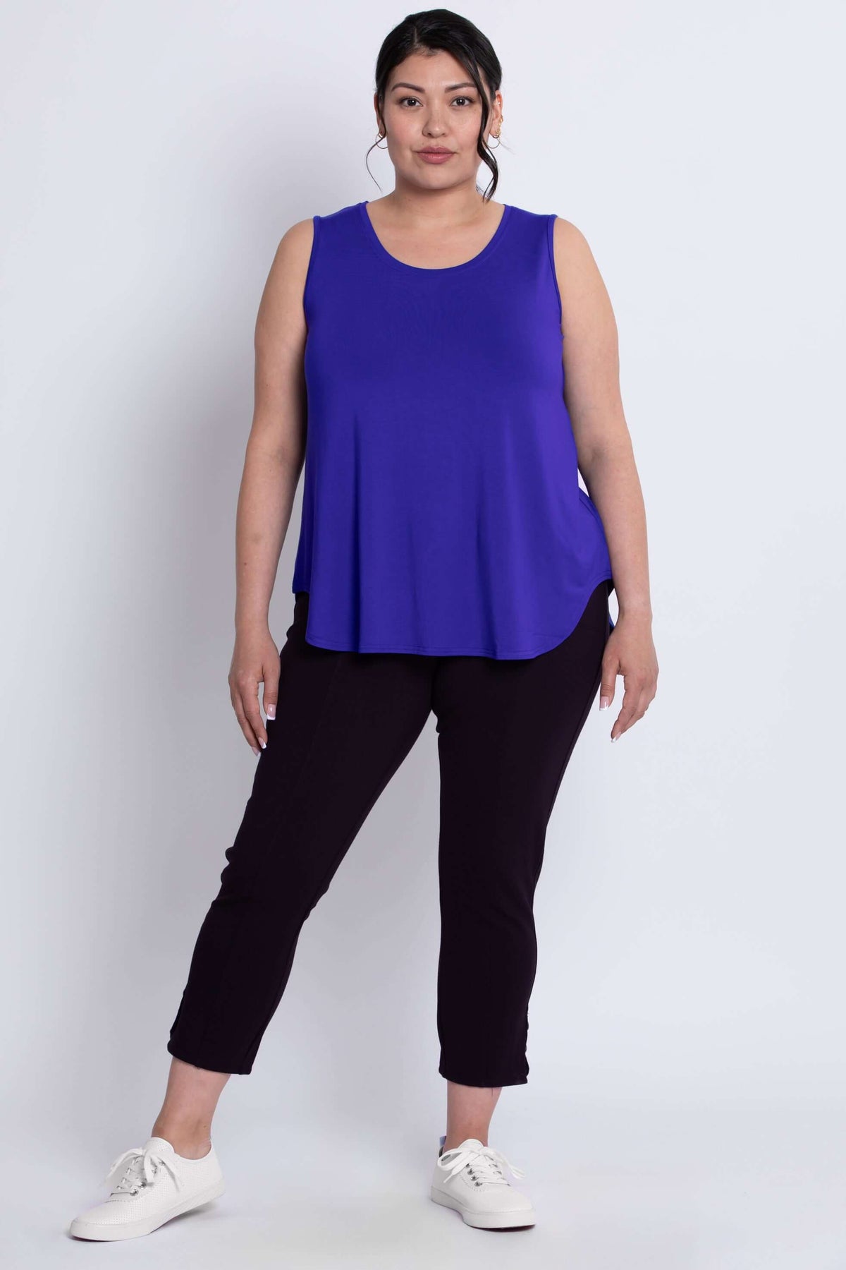 Model wearing grape tank top and black pants, standing at an angle