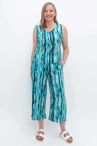 Woman wearing matching teal bamboo linen tank and Landon Capri pants, hands in pockets