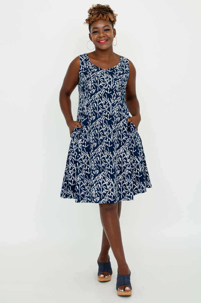 Model wearing a navy and white sleeveless A-line summer dress with pockets, front view