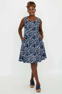 Model wearing a navy and white sleeveless A-line summer dress with pockets, front view
