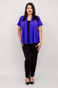 Model standing in a purple open jacket and black pants, hands relaxed