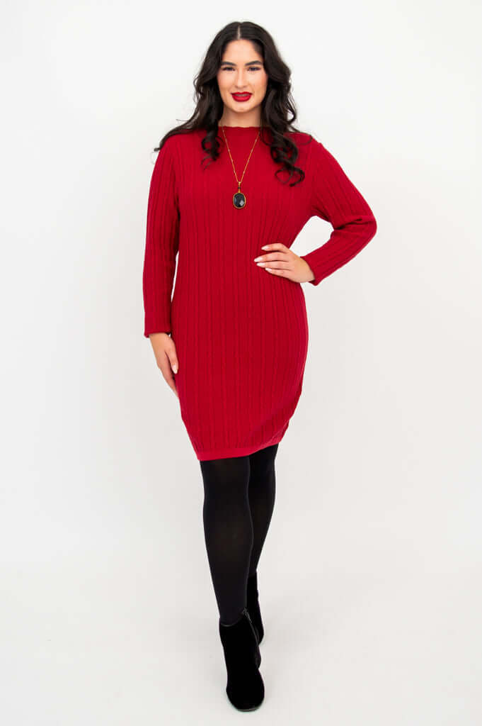 Woman wearing a red cable knit sweater dress with black tights and boots, front view