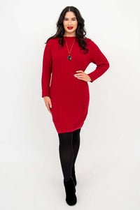 Woman wearing a red cable knit sweater dress with black tights and boots, front view