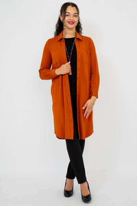 Model in rust duster shirt and black pants facing forward with arms relaxed