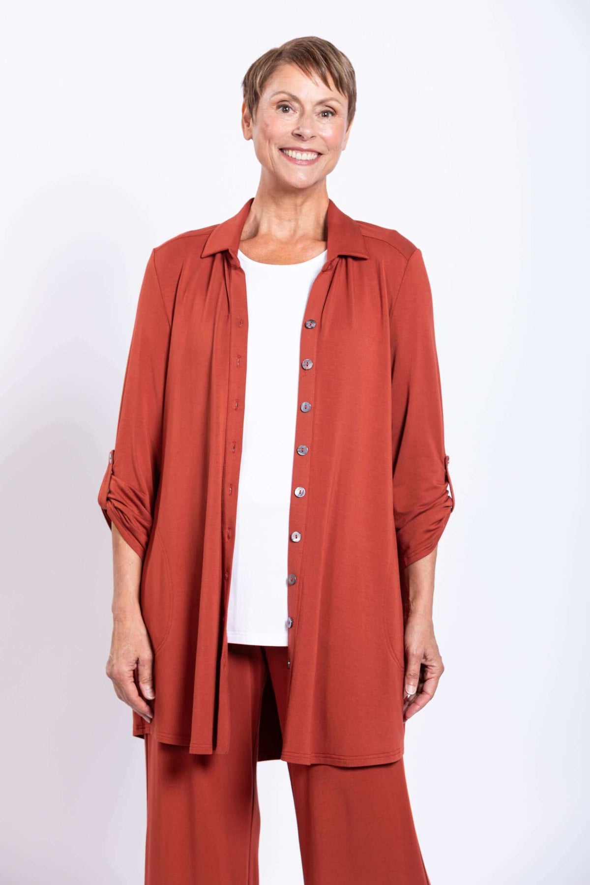 Front view of model in rust bamboo blouse with white top and matching pants