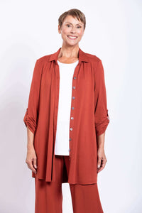 Front view of model in rust bamboo blouse with white top and matching pants