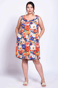 Model in sleeveless floral dress with hands in pockets, front-facing