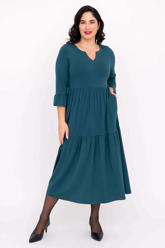 Model wearing teal Bernadette Long Dress with tiered skirt and ruffled sleeves
