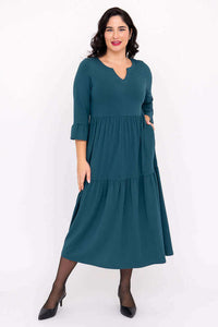 Model wearing teal Bernadette Long Dress with tiered skirt and ruffled sleeves