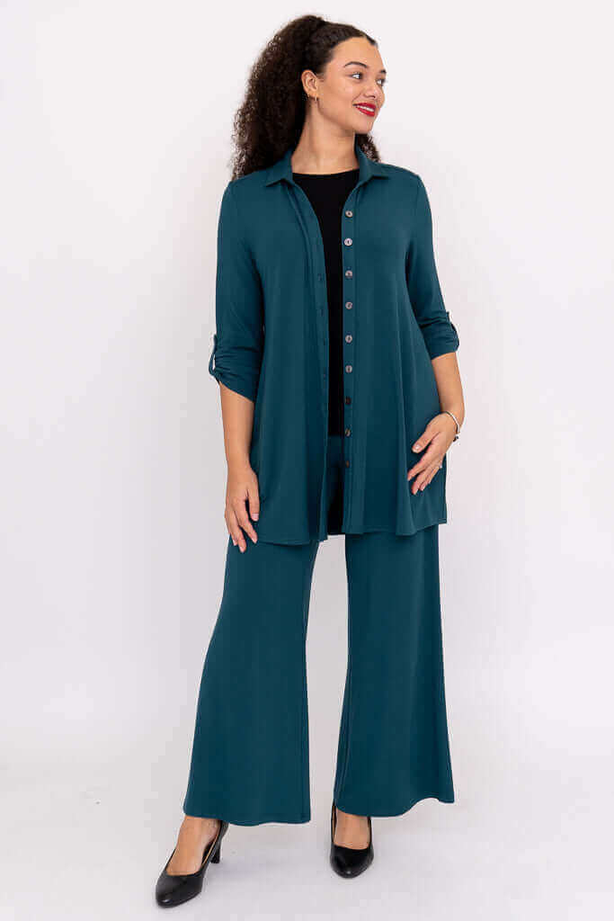 Model in teal wide leg pants with matching buttoned shirt, front view