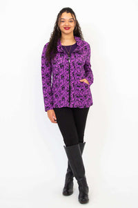 Woman standing front-facing in violet hoodie with hands in pockets and black boots