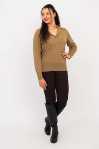 Model in brown V-neck cotton sweater facing left, hands by side