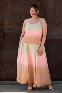 Model outdoors in a gradient peach and pink maxi skirt with matching tank top