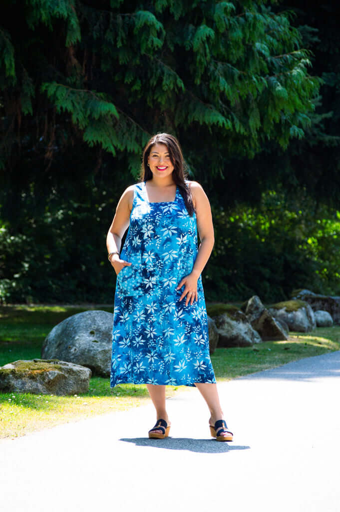 Model outdoors wearing blue floral square neck dress, full length