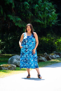 Model outdoors wearing blue floral square neck dress, full length