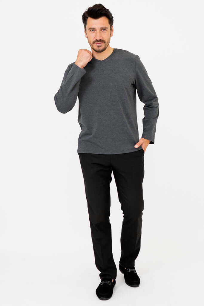 Man posing in dark grey V-neck long sleeve shirt and black pants