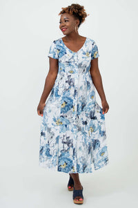 Model smiling and posing in the Morgan dress with blue and white watercolor floral design