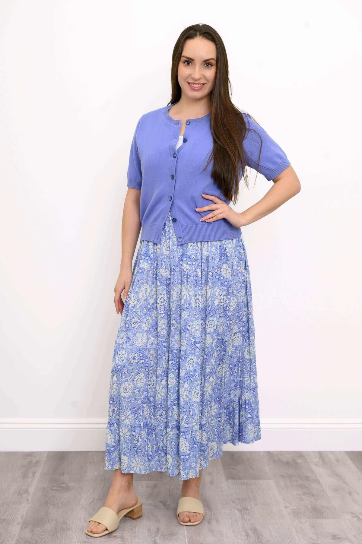 Model posing in Roma tiered blue floral skirt and short-sleeve cardigan
