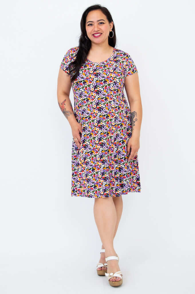 Model posing in a floral print short sleeve dress with a relaxed fit