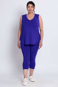 Model in blue capri leggings and sleeveless V-neck top, standing front facing