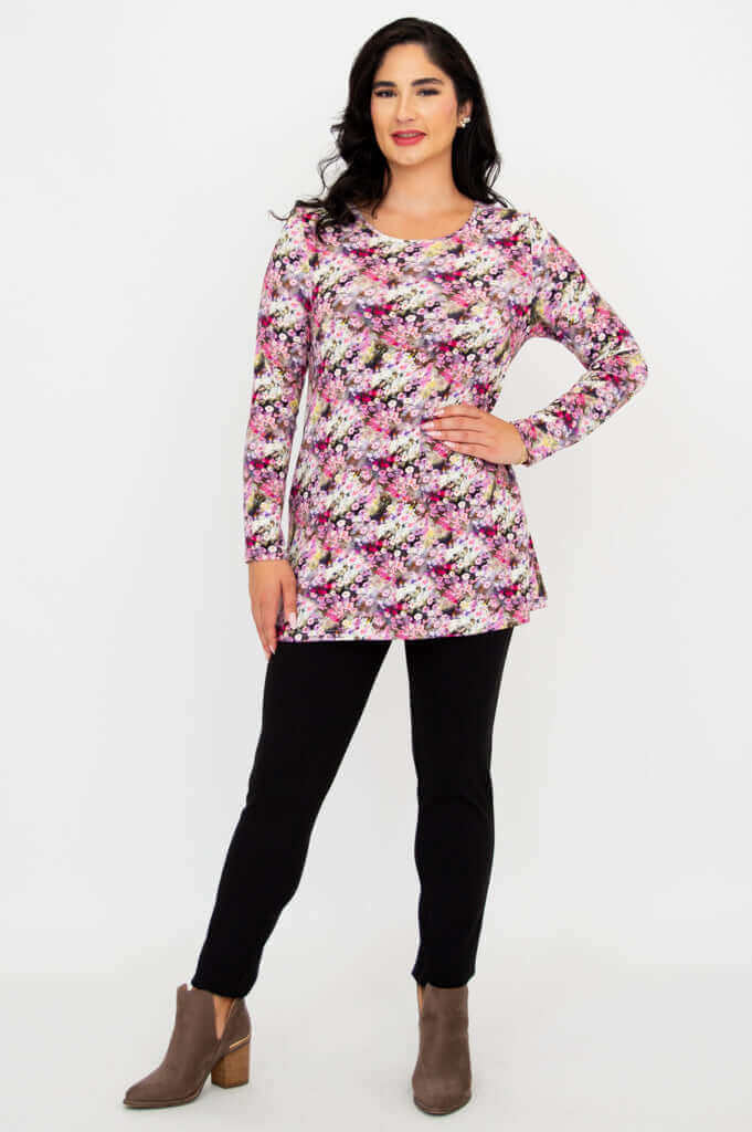 Model posing with hand on hip in floral A-line tunic and black pants