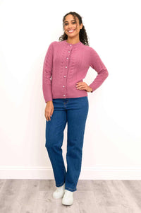 A stylish women's bright pink long sleeve cashmere cardigan sweater on white background with sneakers.
