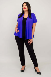Model posing in purple short sleeve open jacket and black pants, hand on hip