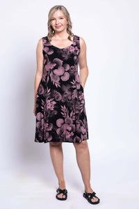 Model posing in sleeveless black dress with pink leaves and flowers