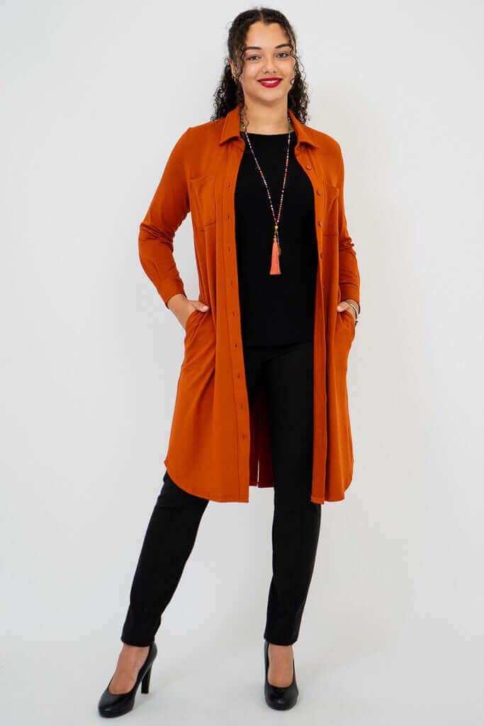 Model posing with both hands in pockets, showcasing rust bamboo duster shirt