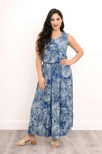Model posing with hand on hip in blue floral sleeveless skirt outfit