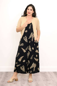 Model with cardigan and black wide-leg jumpsuit in relaxed pose