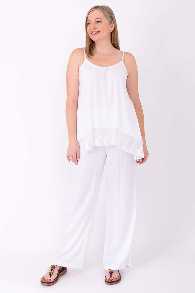 Model turned proudly, wearing white Chantilly Lace Tank and wide-leg pants
