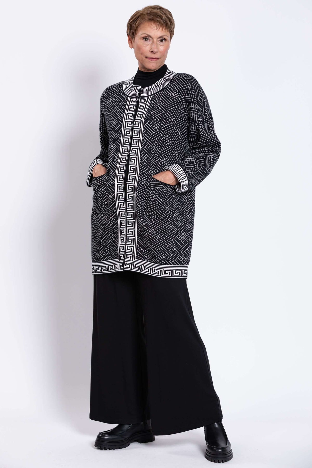 Model showing front pockets and geometric design on a black and white cardigan