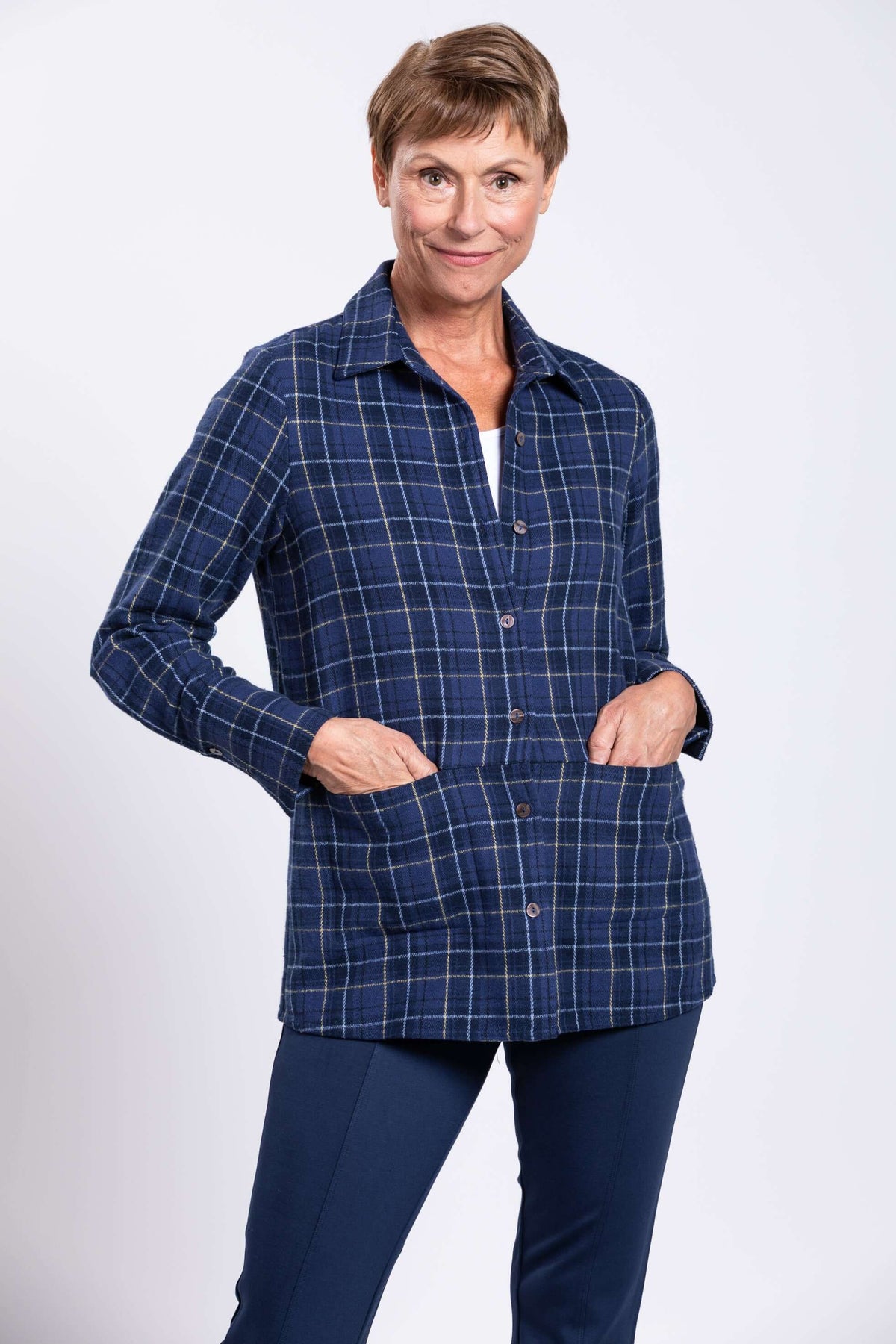 Woman with hands in the pockets of a blue plaid cotton jacket