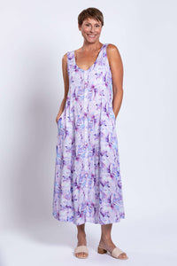 Woman with hands in pockets wearing a watercolor print maxi dress