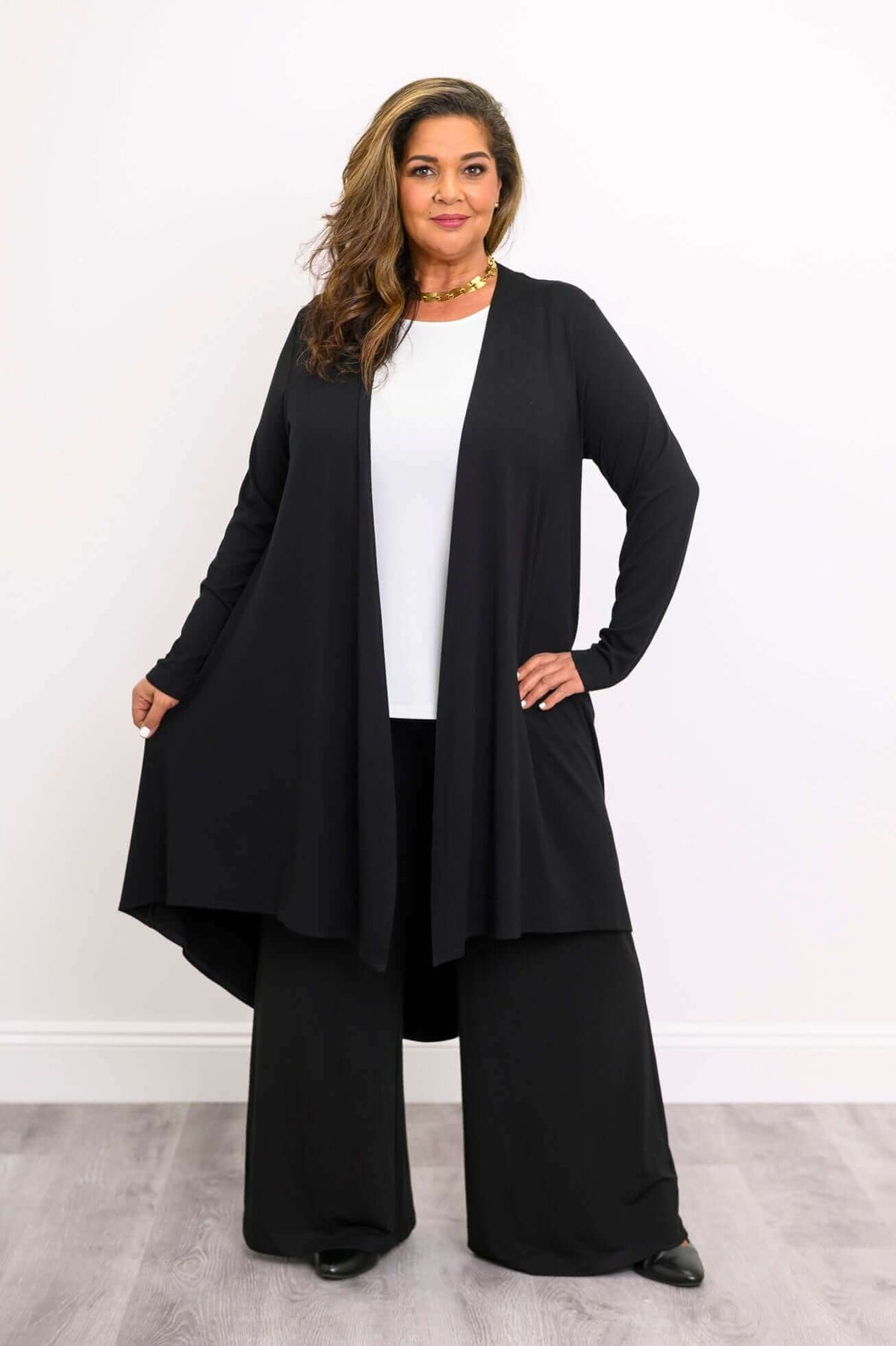 Model showing the drape of a long black bamboo duster with spread hem, front view