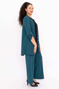 Model side profile wearing teal wide leg bamboo pants and long shirt