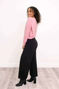 Model side view of the pink cashmere cardigan paired with black pants and boots