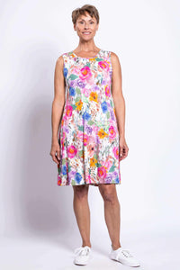 Woman smiling and showing front of bright floral sleeveless dress
